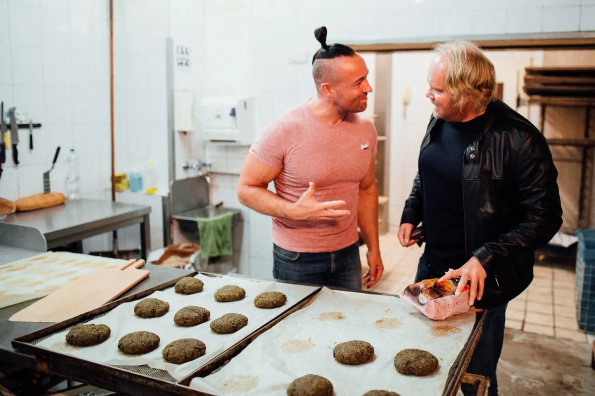 Gründer Stephan Tuchscherer im Gespräch in der Backstube, davor Bleche mit frisch geformten IQ Brötchen